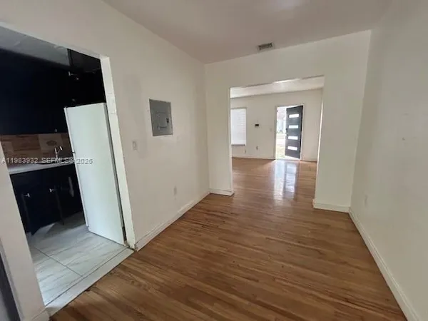 a view of a hallway with wooden floor and closet