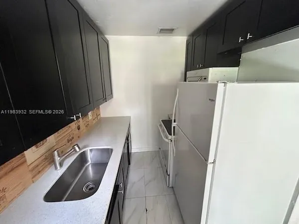 a close view of a sink a refrigerator and washer
