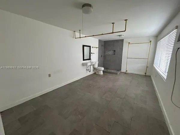 a view of empty room with a fireplace and window