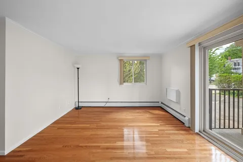 a kitchen with white cabinets and wooden floors