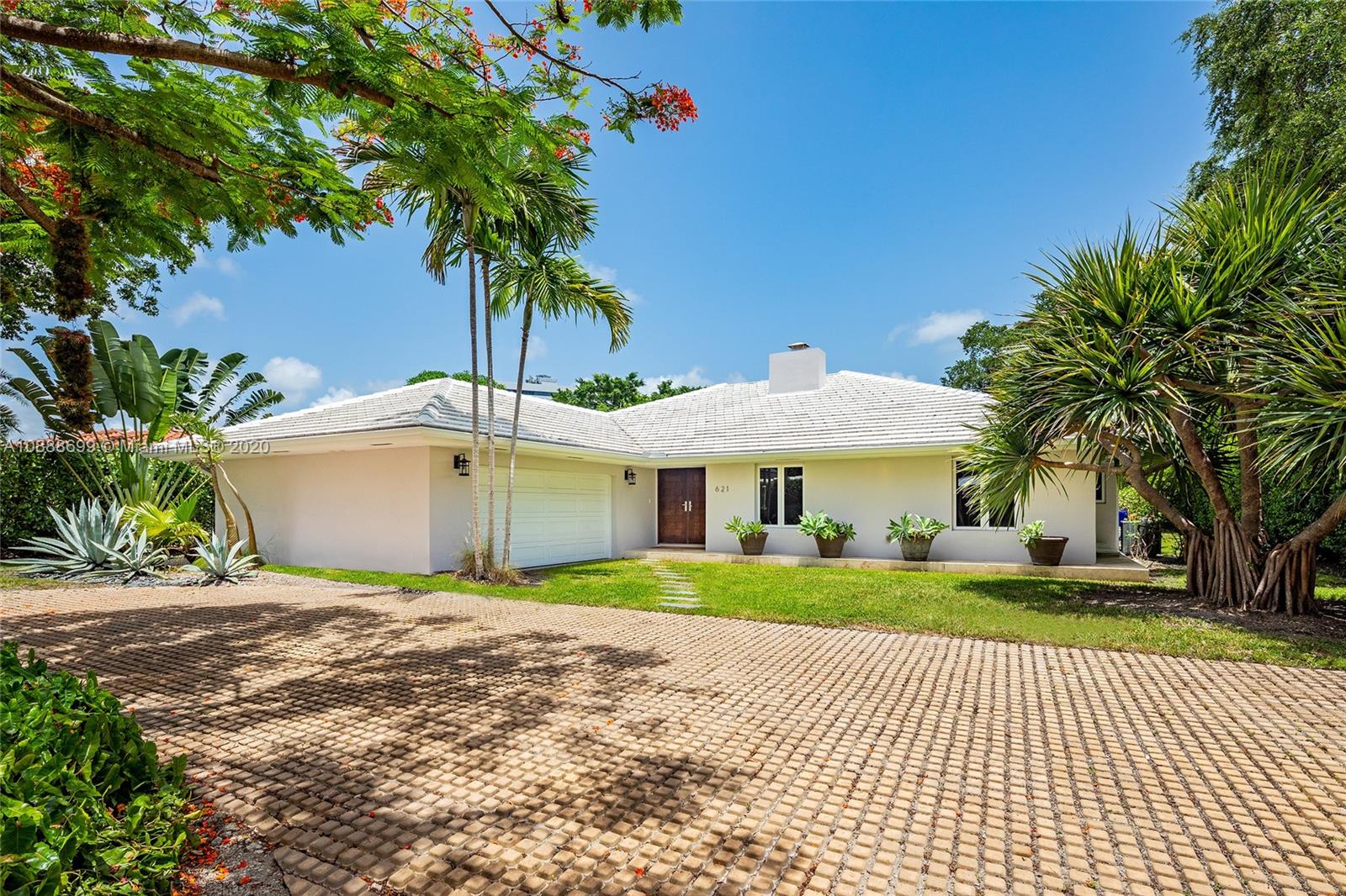 621 Island Road Miami, FL 33137 - Photo 34 of 39 a front view of a house with a garden and trees