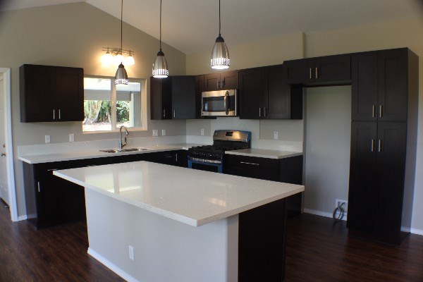 18-7857 Kaniela Road Mountain View, HI 96771 - Photo 8 of 24 a kitchen with stainless steel appliances a sink a microwave a refrigerator and wooden floor