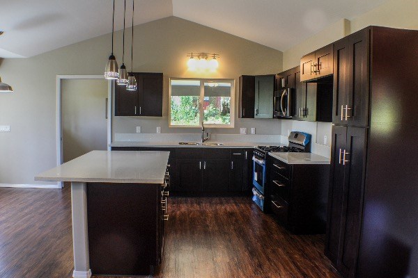 18-7857 Kaniela Road Mountain View, HI 96771 - Photo 10 of 24 a kitchen with stainless steel appliances granite countertop a refrigerator a sink dishwasher a stove and a microwave oven on granite countertops