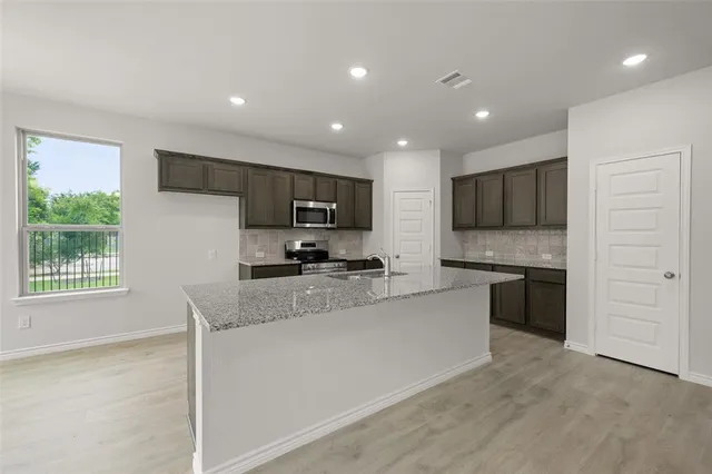 a kitchen with stainless steel appliances granite countertop sink microwave and cabinets