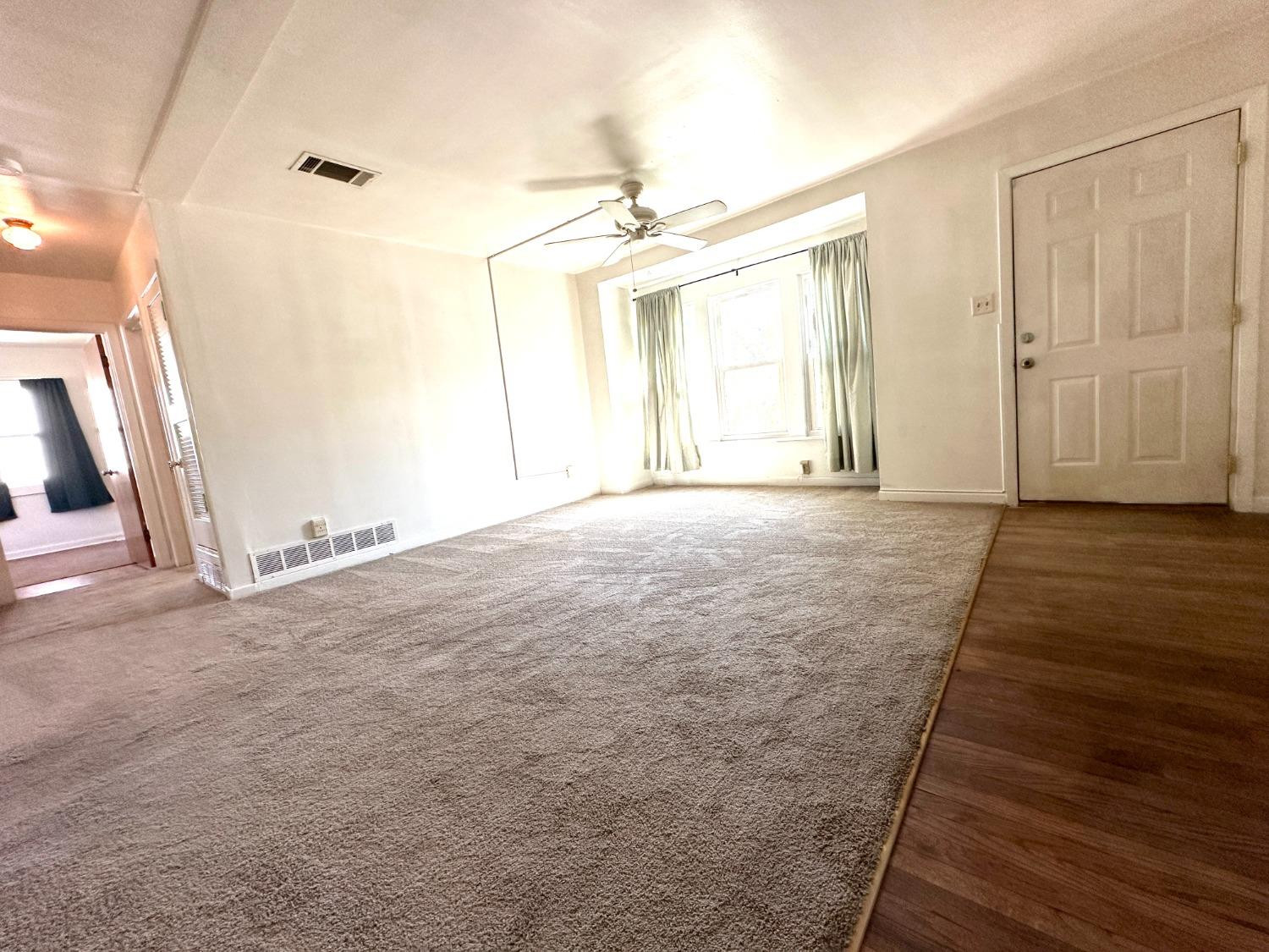 3004 43rd Street Lubbock, TX 79413 - Photo 3 of 8 an empty room with wooden floor and windows