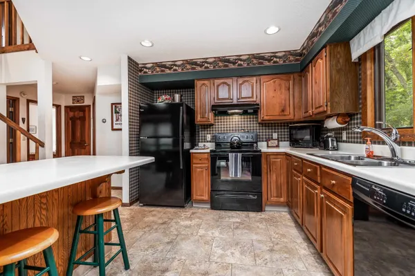 a kitchen with stainless steel appliances granite countertop a stove a sink dishwasher and a refrigerator