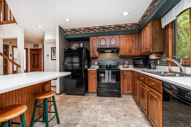 a kitchen with stainless steel appliances granite countertop a stove a sink dishwasher and a refrigerator