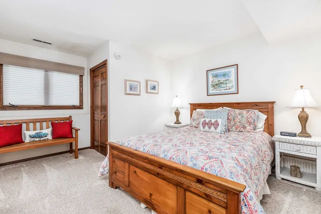 a bedroom with a bed and paintings on the wall