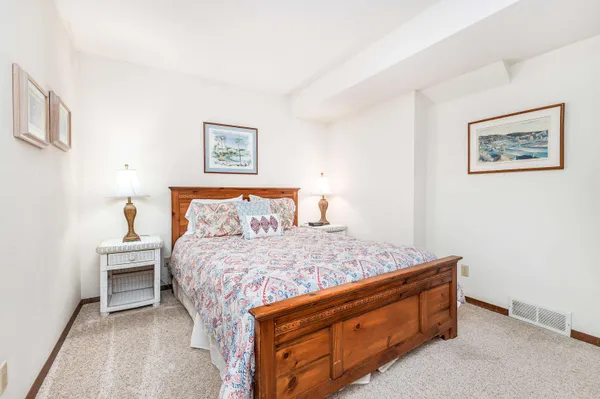 a bed sitting in a bedroom next to a lamp