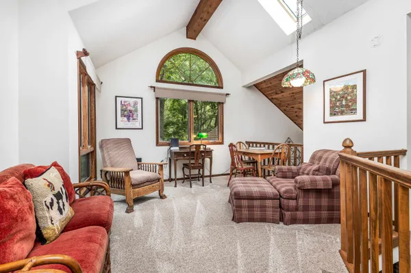 a living room with furniture chandelier and a large window