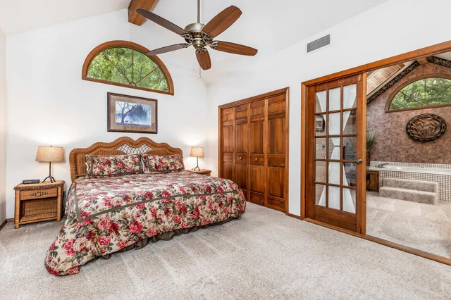 a bedroom with a bed and a large window with the outer view