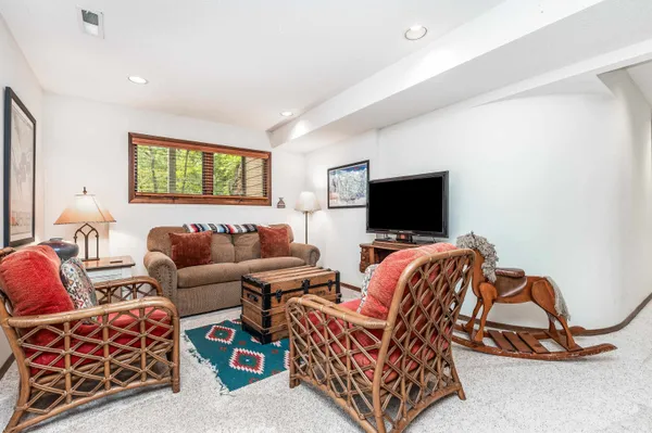a living room with furniture a flat screen tv and a floor to ceiling window