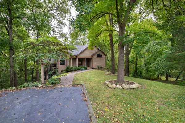 a front view of a house with a yard and green space