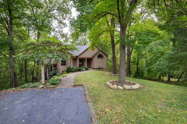 a front view of a house with a yard and green space