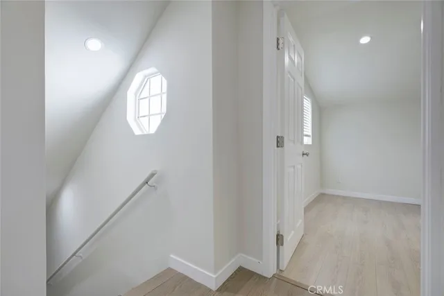 an empty room with wooden floor and mirror