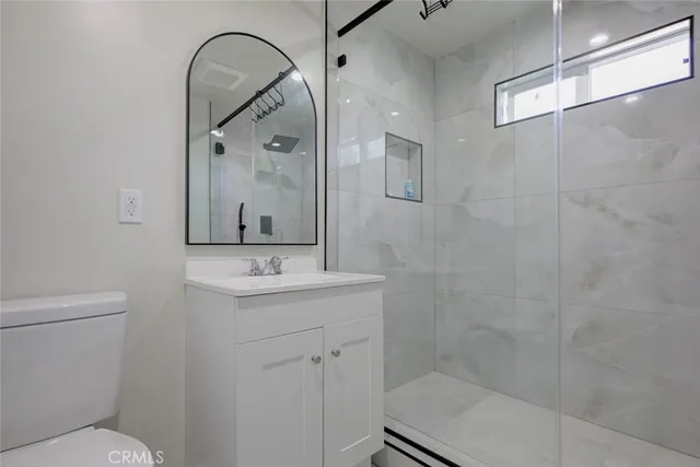 a bathroom with a sink a toilet and shower