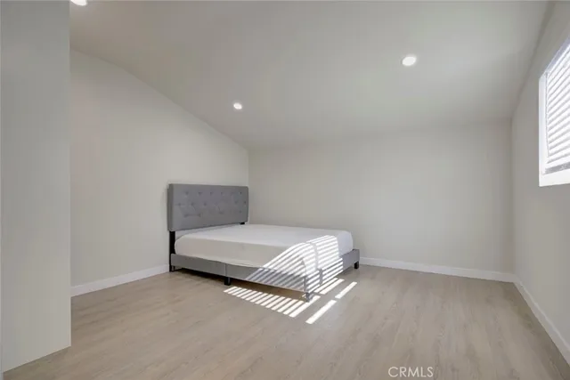 a spacious bedroom with a bed and a window