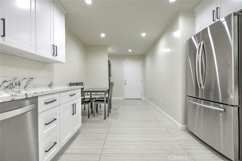 7711 Forsyth Street Tujunga, CA 91042 - Photo 6 of 35 a kitchen with white cabinets and stainless steel appliances
