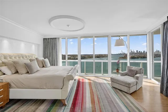 a bedroom with a large bed and a flat tv screen on dresser