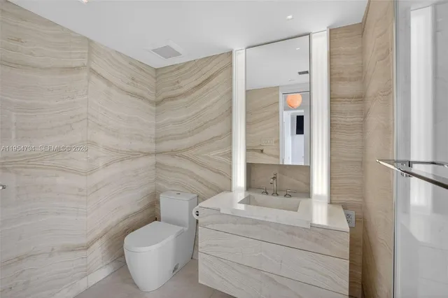 a pathway of a house with potted plants and a large tree