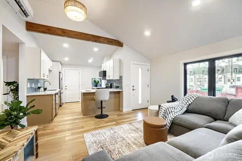 a living room with furniture kitchen view and a potted plant