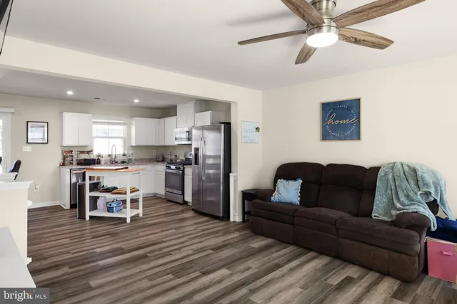 a living room with furniture and a dining table with kitchen view