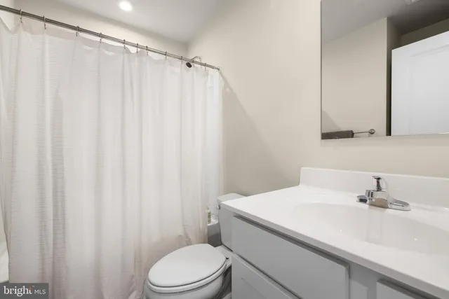 a bathroom with a sink a toilet and shower curtain
