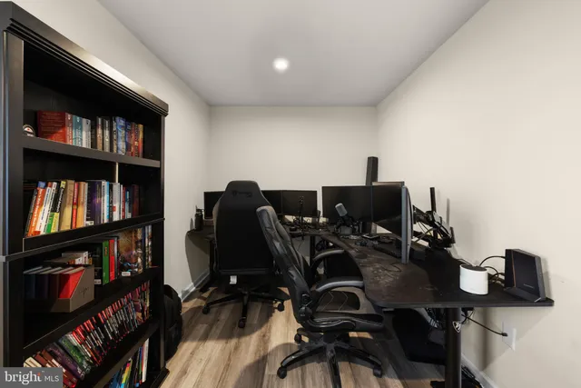 a view of a workspace with furniture and a book shelf