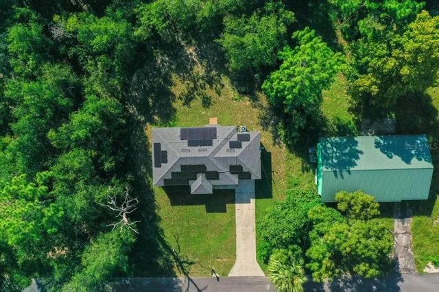an aerial view of a house with a yard basket ball court and outdoor seating