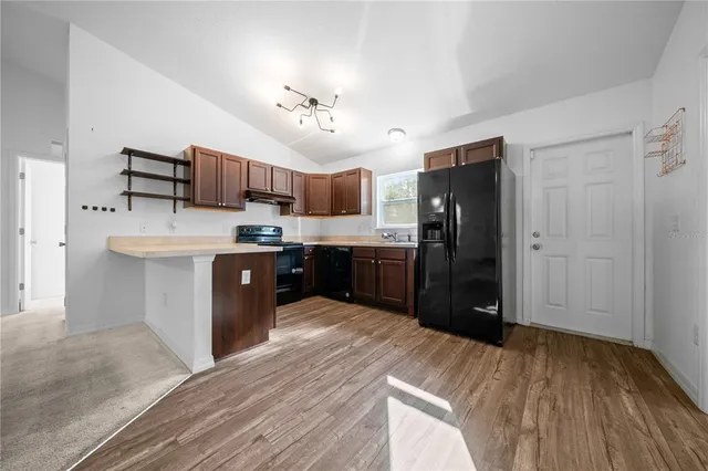 a kitchen with stainless steel appliances granite countertop a refrigerator and a stove top oven