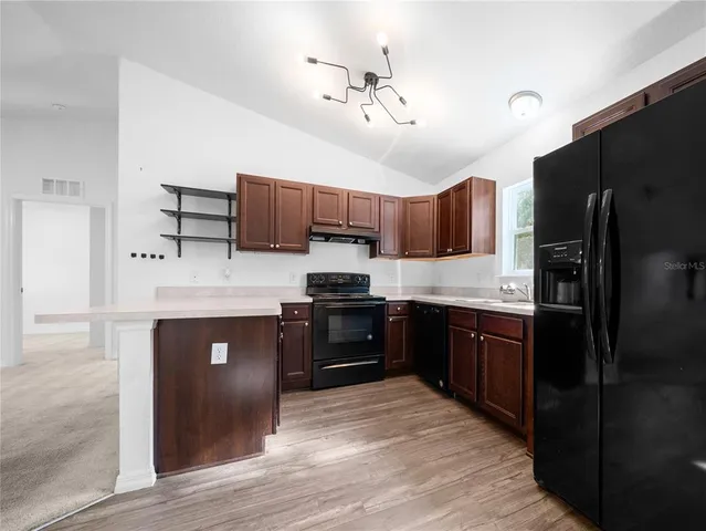 a kitchen with stainless steel appliances granite countertop a refrigerator stove top oven and sink