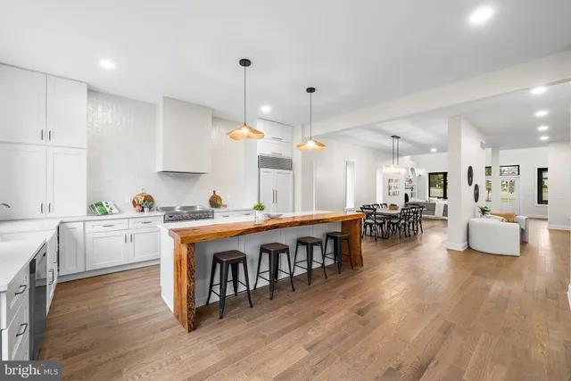 a large white kitchen with lots of counter space and stainless steel appliances