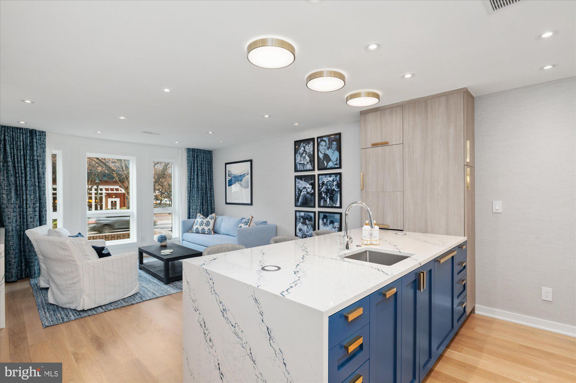 a view of kitchen island a sink wooden floor and living room