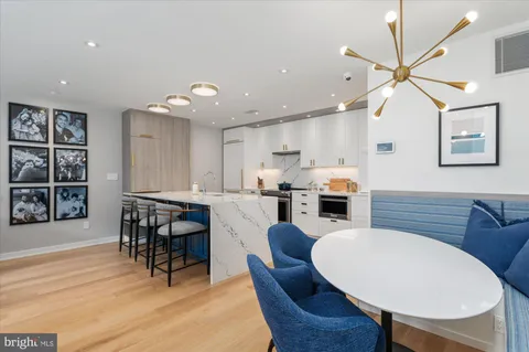 a kitchen with kitchen island wooden cabinets and dining table