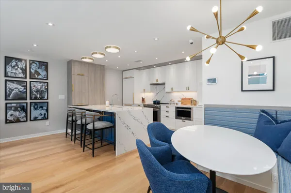 a kitchen with kitchen island wooden cabinets and dining table