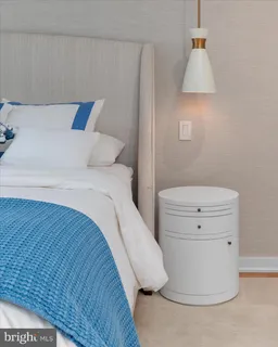 a bedroom with a bed and a lamp on the dresser