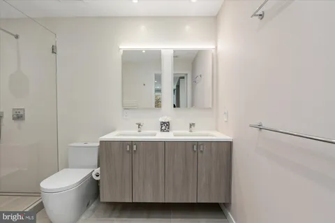 a bathroom with a toilet a sink a mirror and vanity
