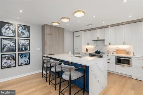 a kitchen with a stove a sink cabinets and wooden floor