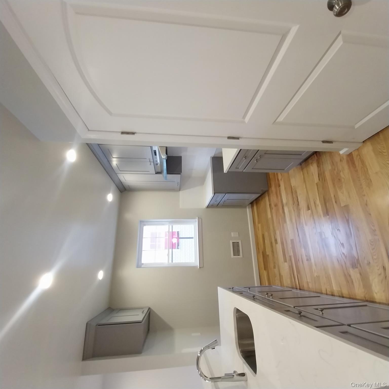343 Jackson Street, Unit 1 Hempstead, NY 11550 - Photo 12 of 31 a kitchen with cabinets and window