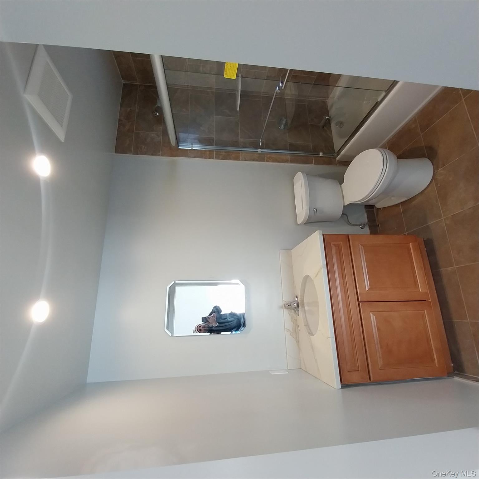 343 Jackson Street, Unit 1 Hempstead, NY 11550 - Photo 15 of 31 a bathroom with a toilet sink and a mirror