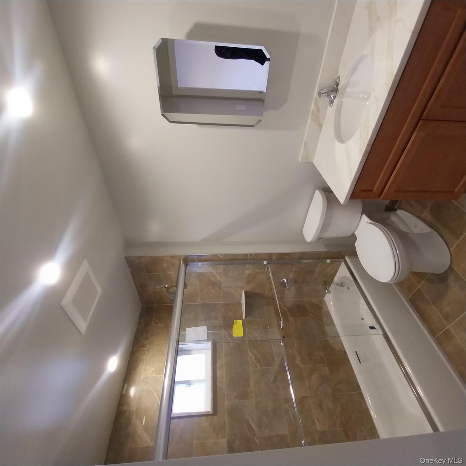 343 Jackson Street, Unit 1 Hempstead, NY 11550 - Photo 16 of 31 a bathroom with a granite countertop bathtub shower sink mirror and toilet