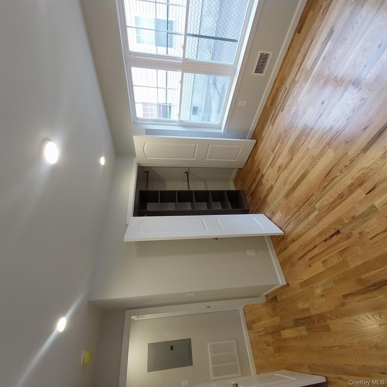343 Jackson Street, Unit 1 Hempstead, NY 11550 - Photo 19 of 31 an empty room with wooden floor and windows