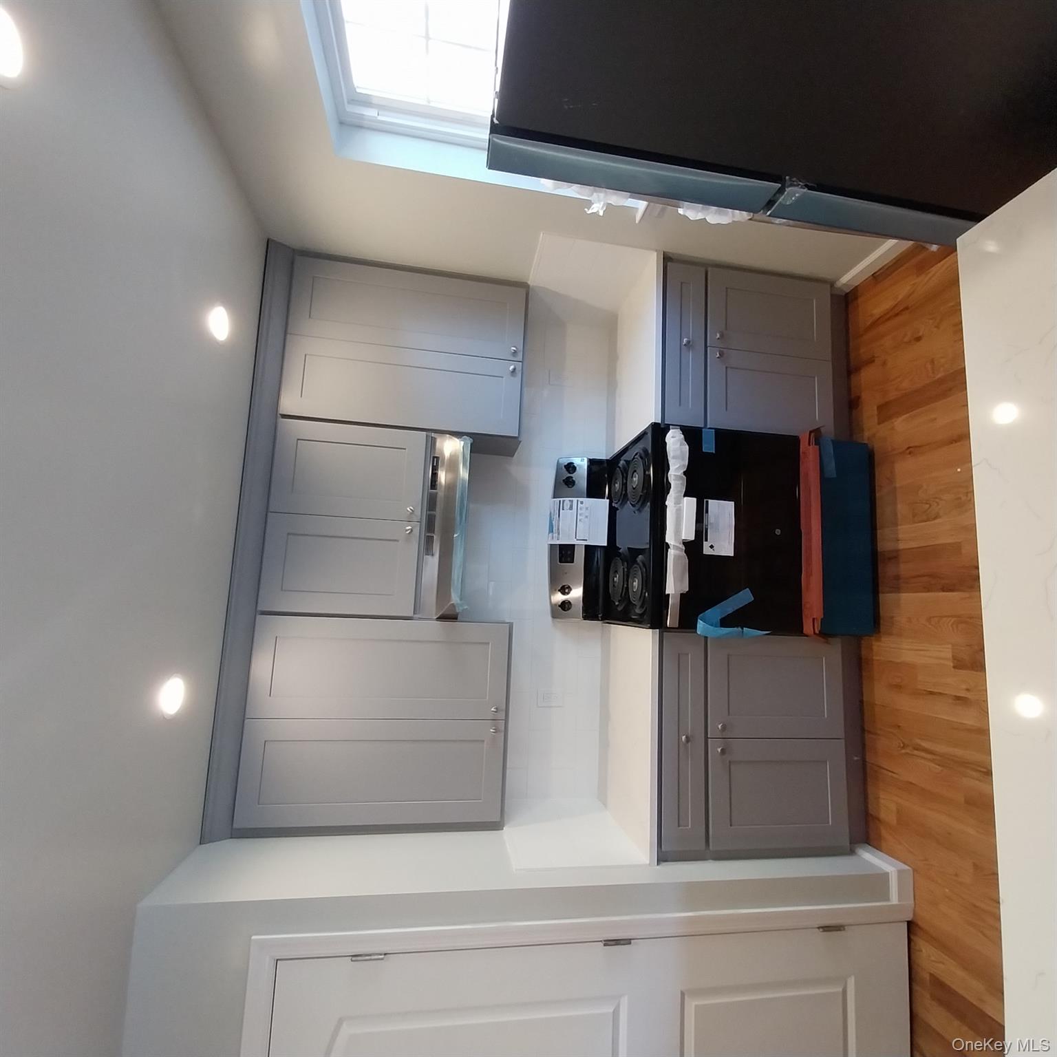 343 Jackson Street, Unit 1 Hempstead, NY 11550 - Photo 23 of 31 a kitchen with a sink a refrigerator and wooden floor