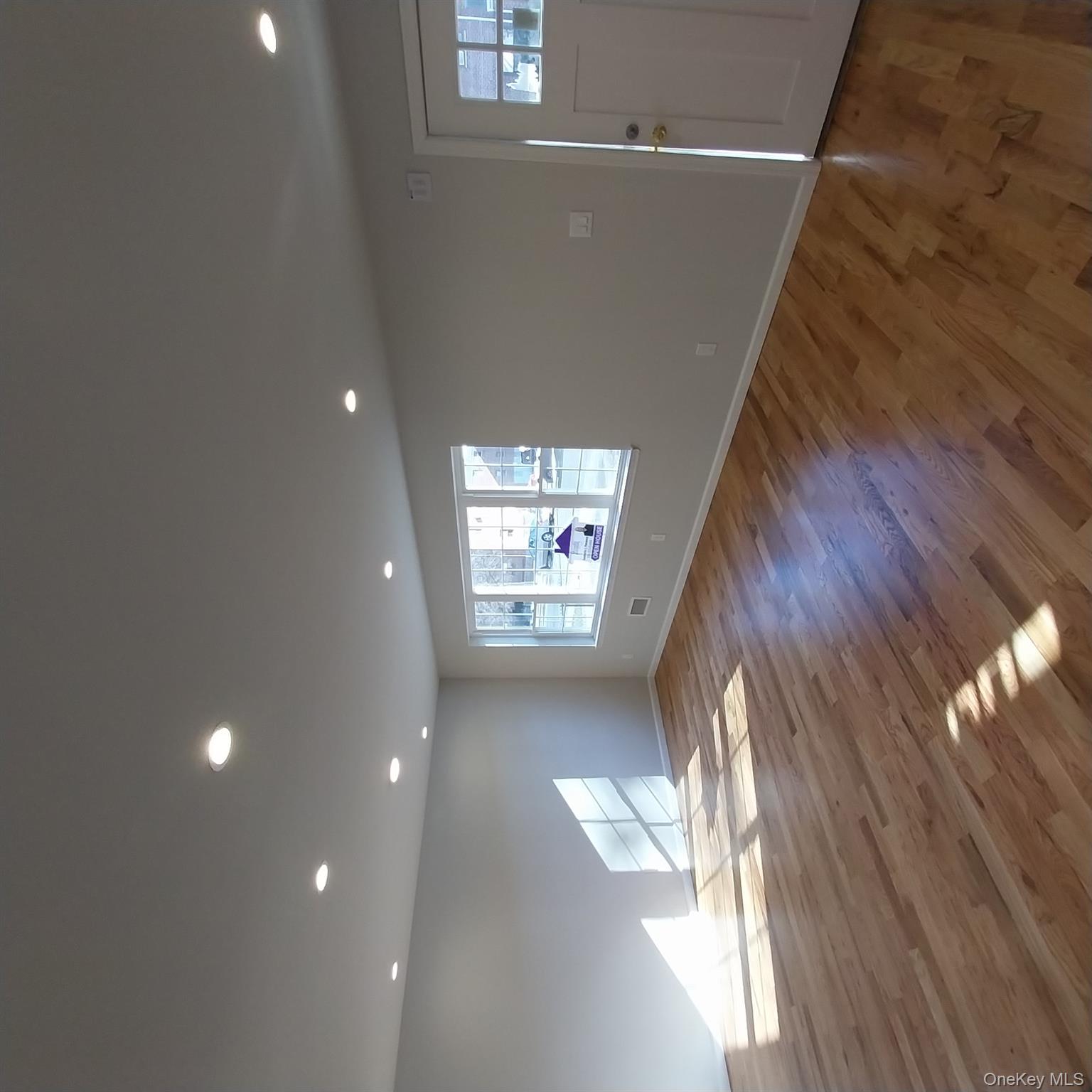 343 Jackson Street, Unit 1 Hempstead, NY 11550 - Photo 25 of 31 a view of empty room with wooden floor and window