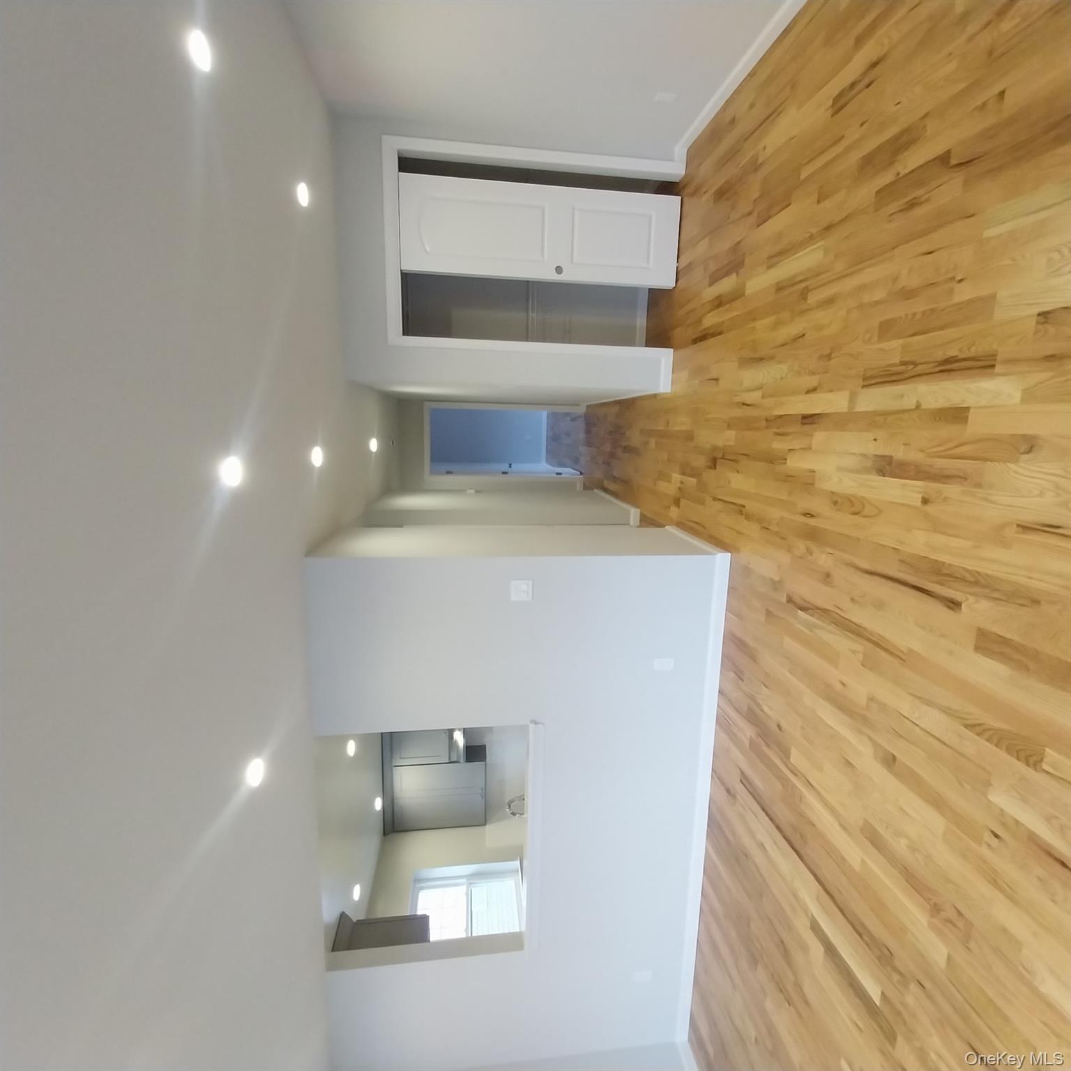 343 Jackson Street, Unit 1 Hempstead, NY 11550 - Photo 4 of 31 a view of a big room with wooden floor and windows