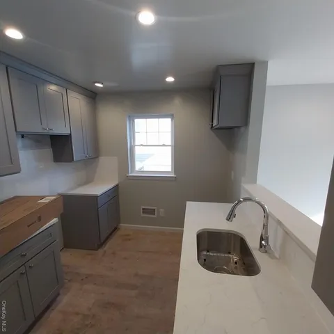 a kitchen with stainless steel appliances a sink a stove a refrigerator a window