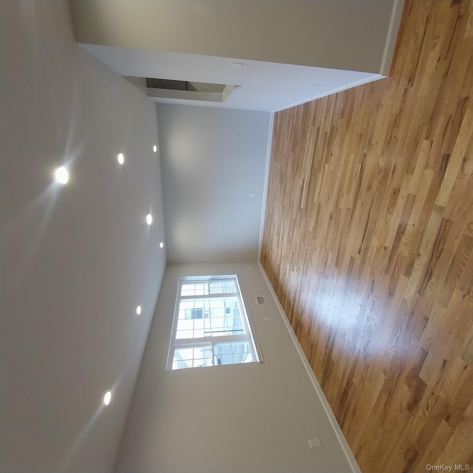 343 Jackson Street, Unit 1 Hempstead, NY 11550 - Photo 8 of 31 an empty room with wooden floor and windows