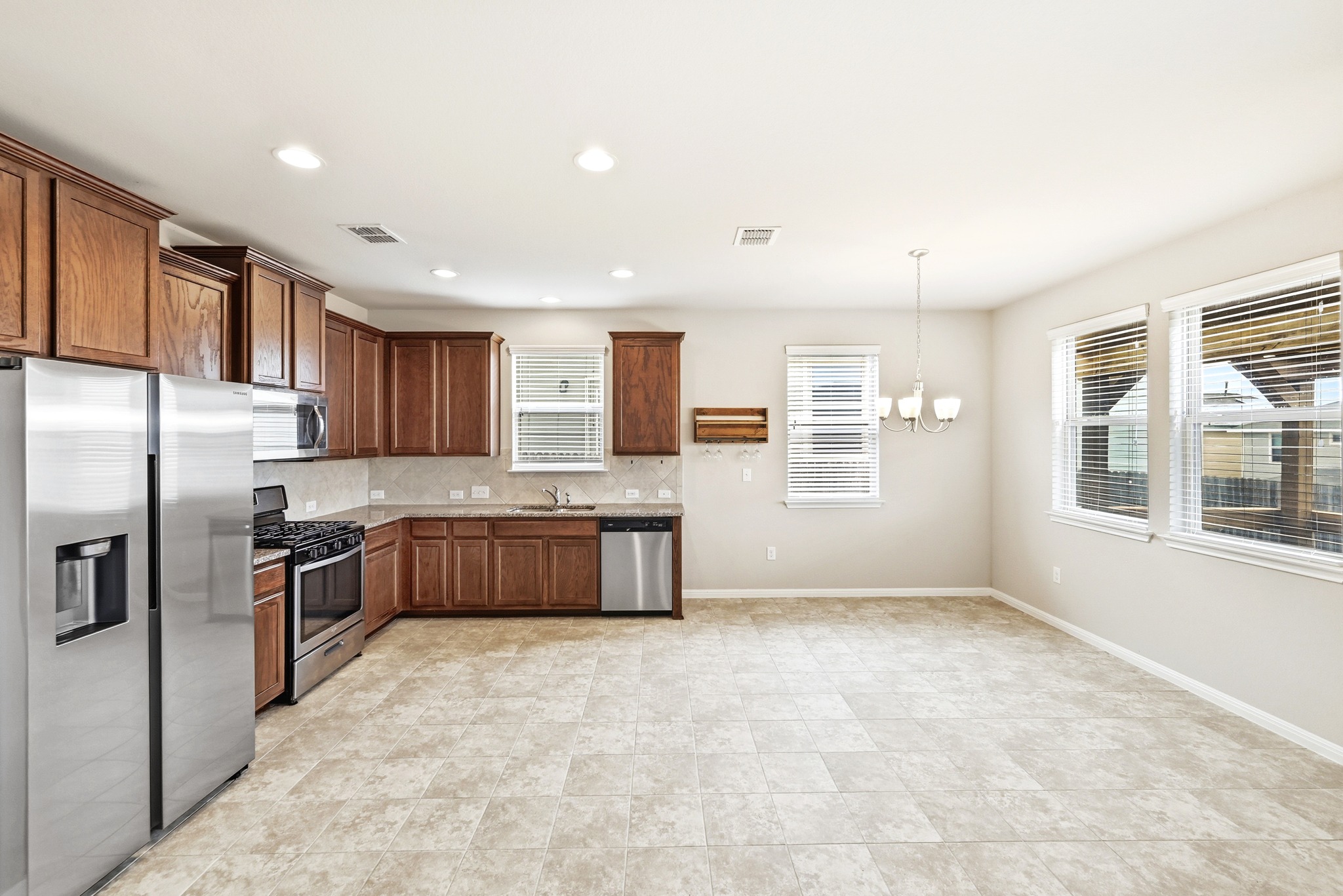 171 Vestral Road Buda, TX 78610 - Photo 12 of 26 Light and bright kitchen with stainless steel appliances, tasteful backsplash, and dining area