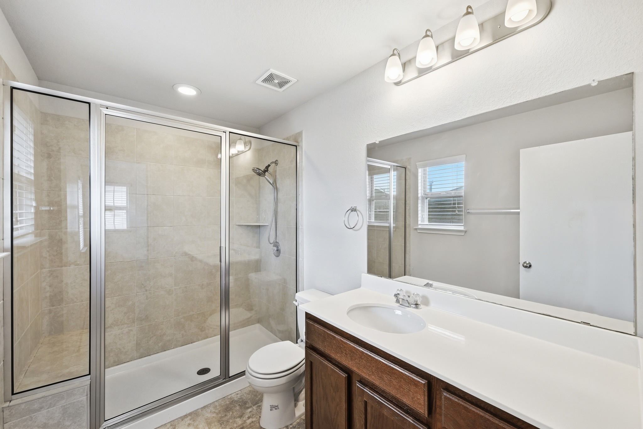 171 Vestral Road Buda, TX 78610 - Photo 18 of 26 Primary bathroom with vanity, a walk in shower, and recessed lighting