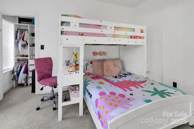 a bedroom with baby bed and two windows